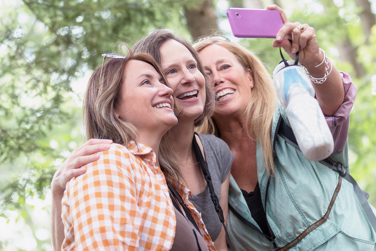 Three women taking a selfie in the woods