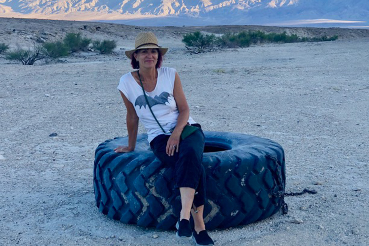 Corinne Farago sitting on a tire in the desert